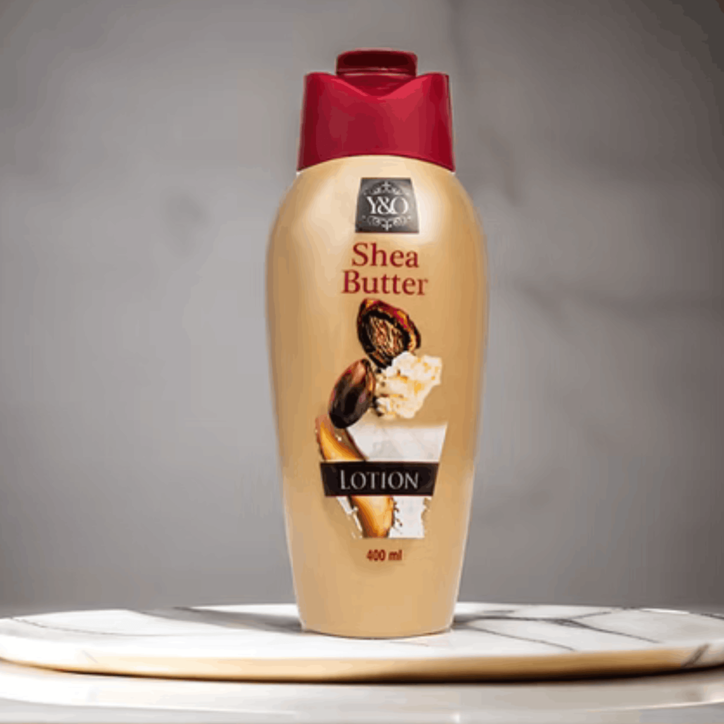 Shea butter lotion bottle with a red cap on a gray background