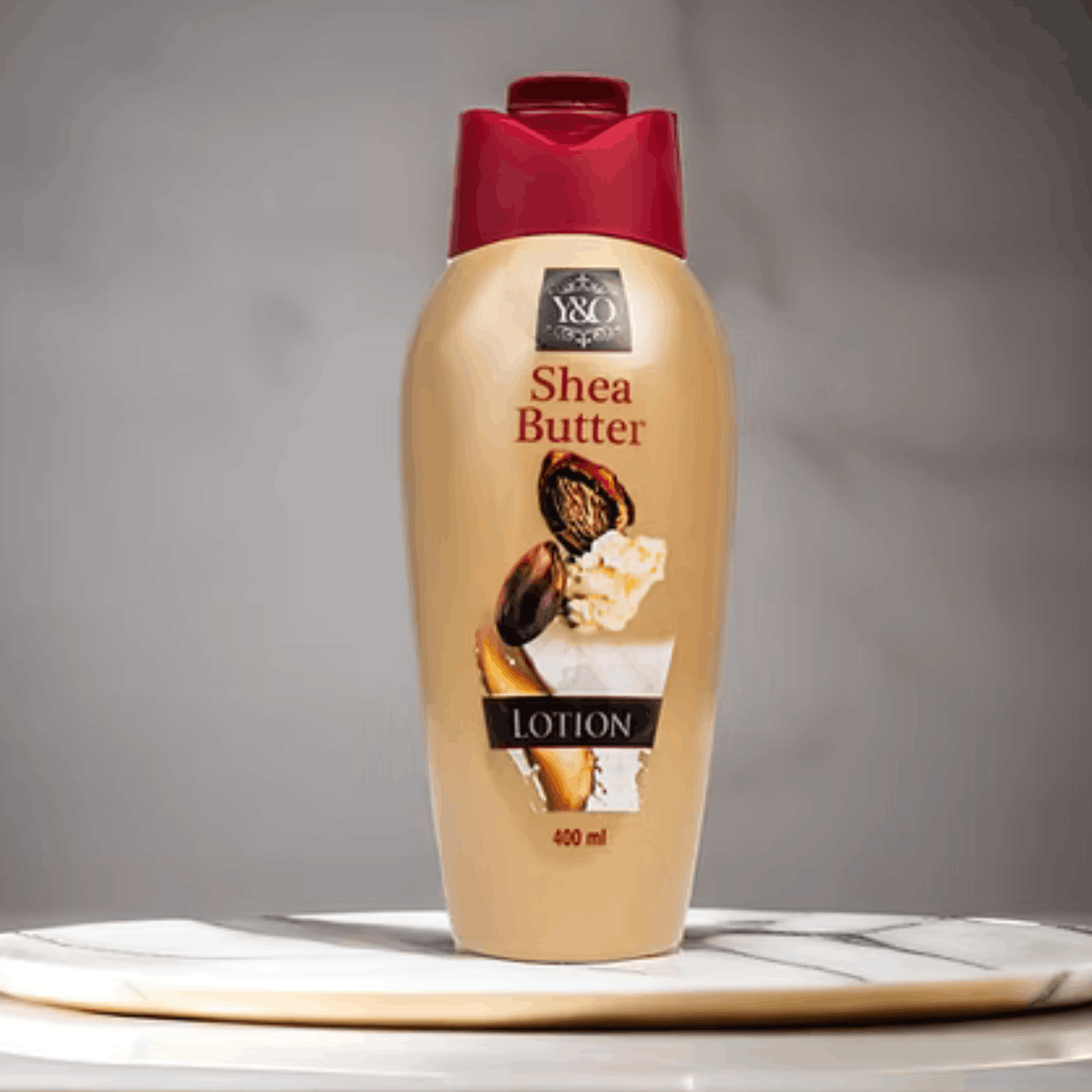 Shea butter lotion bottle with a red cap on a gray background